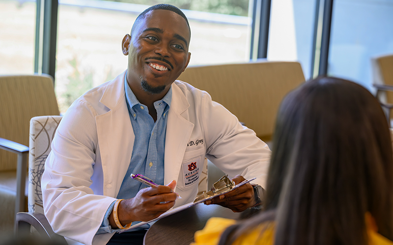 Student engages with patient while holding clipboard