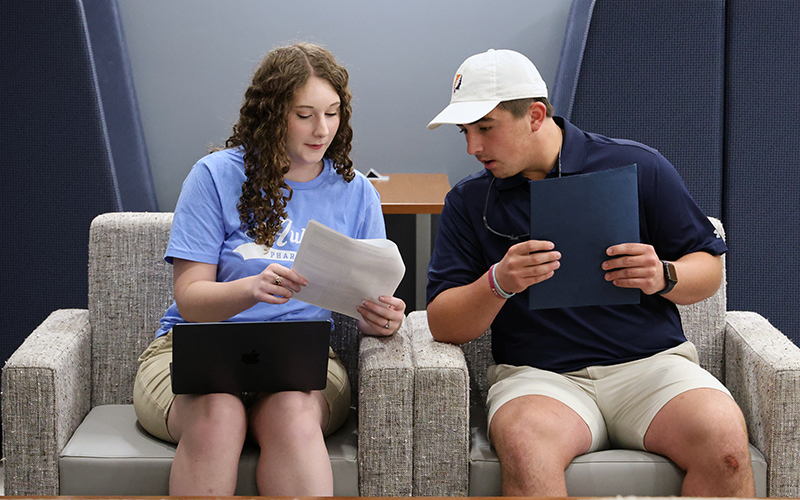 Two students in chairs studying together