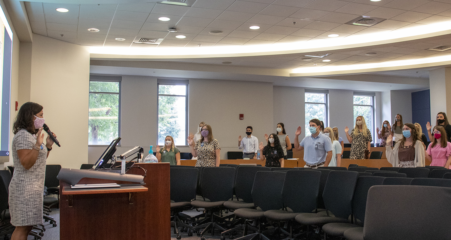 Students stand to take an oath