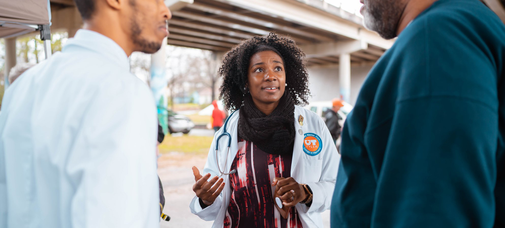 Pharmacist speaks in between two people