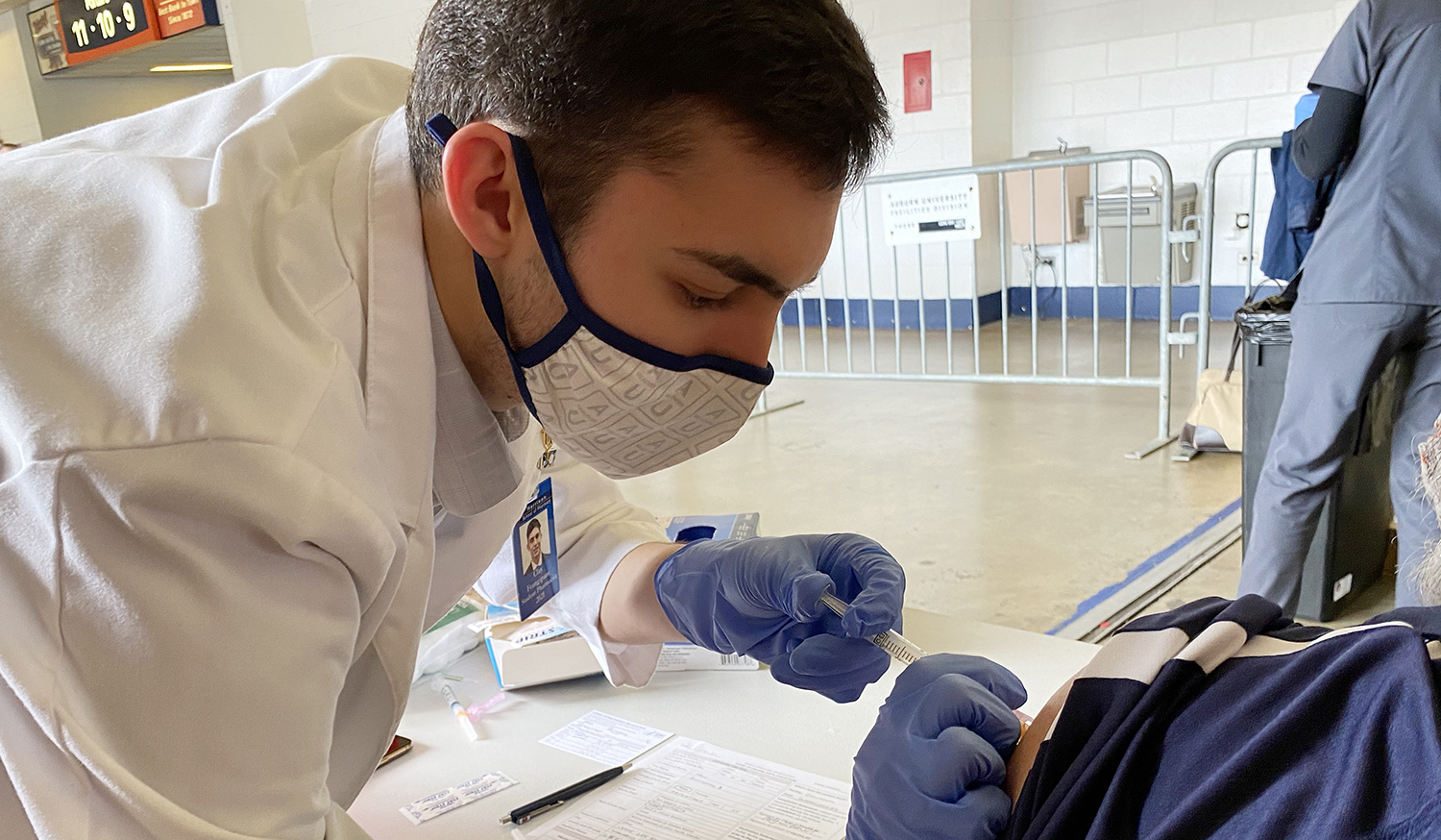 Student gives vaccine to patient