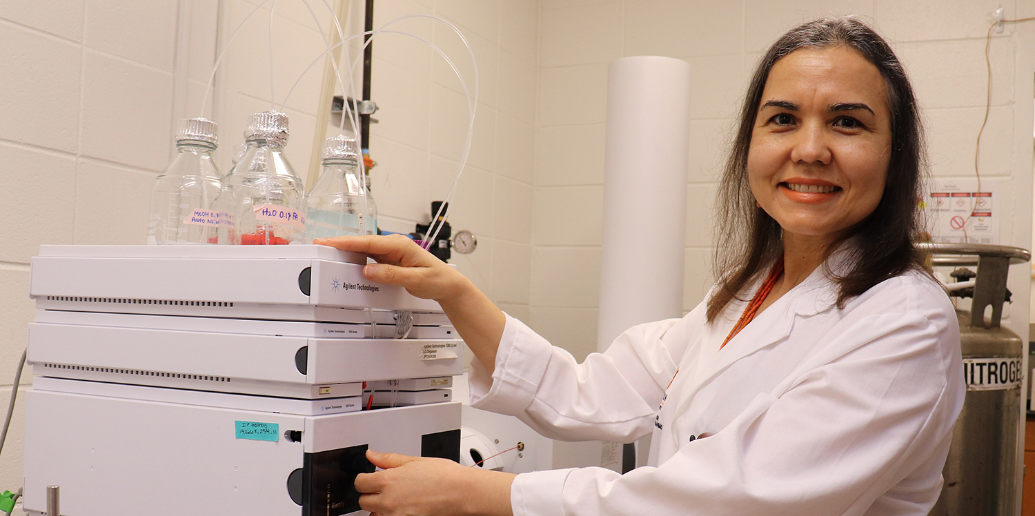 Dr. Calderon stands by equipment in lab